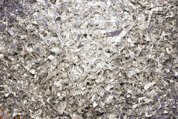 Silver confetti background. Bright shiny confetti lying on the table. Top view.