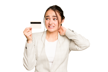 Young caucasian woman holding a credit card isolated on green chroma background touching back of head, thinking and making a choice.