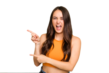Young caucasian woman isolated on green chroma background pointing with forefingers to a copy space, expressing excitement and desire.