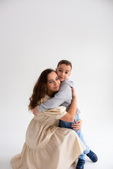  Boy preschooler and mother smile and hug on gray background in photo studio