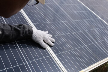 Engineers inspecting solar panels. A close-up of the engineer's hand inspecting solar cells closely...