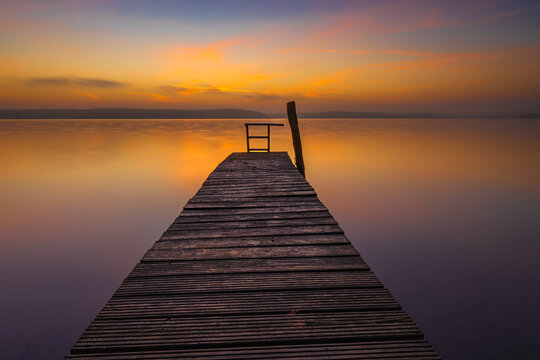 Sonnenaufgang &uuml;ber einem Bootssteg am Ufer des Plauer Sees in Plau am See in der Mecklenburgischen Seenplatte