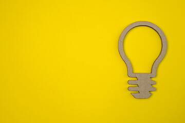 Light bulb cut out on a corrugated cardboard. Flat lay design symbol of idea with cardboard lamp on background.