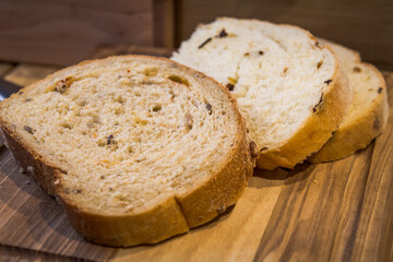Close up slice of bread concept photo. Fresh and savoury food. Bakery. Front view photography with cutting board on background. High quality picture for wallpaper, travel blog, magazine, article