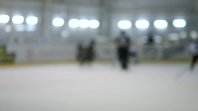 Blurred background. Teams of hockey players playing hockey. Teenage boys play hockey on ice rink at indoor ice stadium. Ice Hockey match championship Sports skating competitions Real professional game