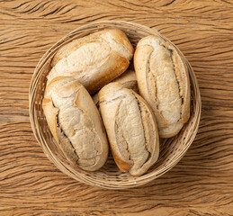 Whole grain french bread, salt bread or pistolet in a basket over wooden table