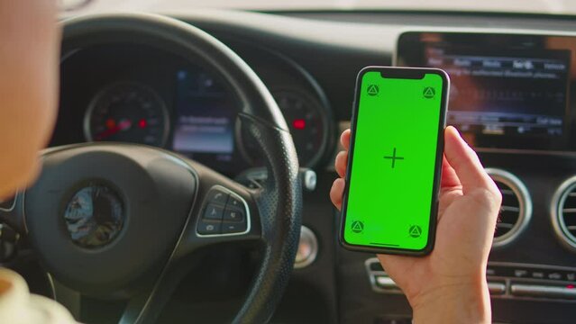 Man Driver Phone Hand with a Green Screen Chroma Key, Male driver checks route on smartphone while sitting at the Car, Modern Application