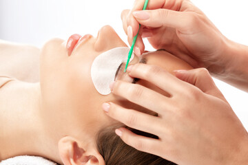 Make-up artist makes the procedure of lamination and dyeing of eyelashes to a beautiful woman in a...