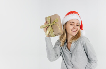 Young blonde girl in a Santa hat holds gifts in her hand on a white background