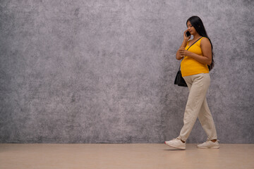 Pregnant woman talking on mobile phone while walking