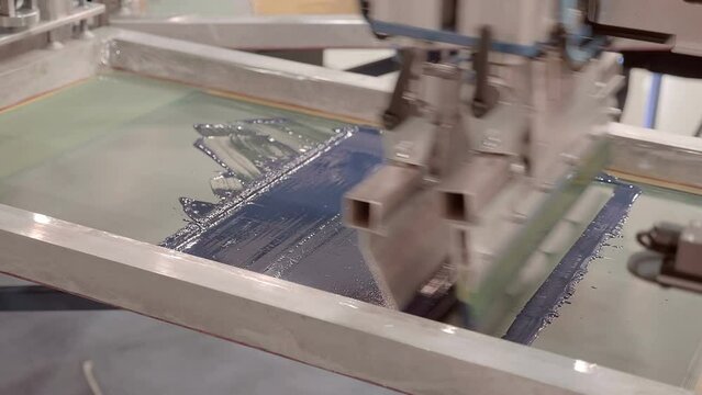 Equipment for serigraphy printing, carousel type - printing on fabric by layers through a stencil, image of different colors. Closeup
