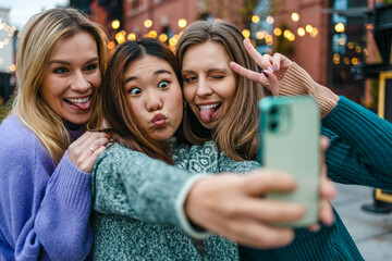 Three girlfriends having fun taking a selfie
