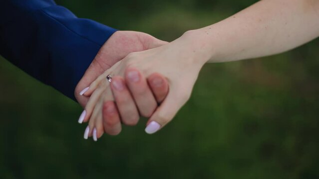 A man takes his woman's hand with tenderness. Taken in close-up