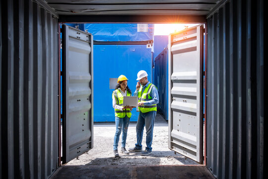 Engineer Working In The Construction Container Dock Yard Checking And Inspection Containers Data On Laptop Program Is Container Shipping Logistics Business Concept.