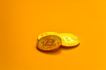 Three yellow bitcoin beans laying on flat surface