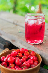 Glass of sour cherry juice with fresh red cherries, Cherry juice, on wood background, red drink, High vitamin C and antioxidant fruits.