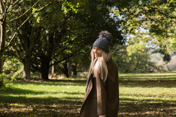 Naklejka premium Close up of a woman walking in a forest in wooly hat and coat