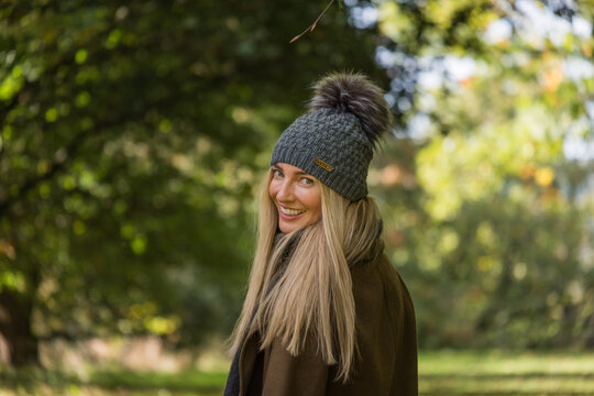 Close up of a woman walking in a forest in wooly hat and coat
