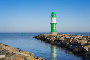 The small green lighthouse in Warnemünde at the harbour entrance of Rostock