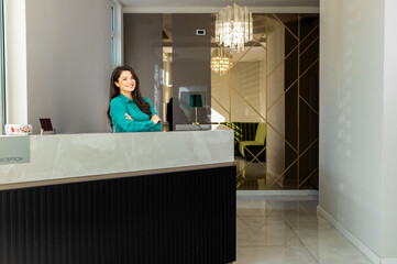 Portrait of female receptionist at desk in lobby.