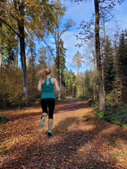 Junge Frau joggt im herbstlichen Wald