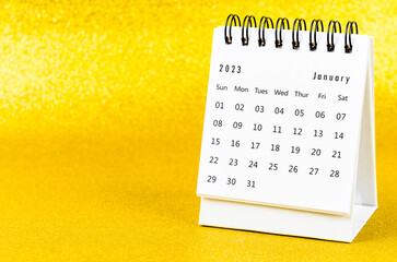 The January 2023 Monthly desk calendar for 2023 year on golden color background.