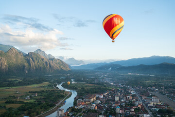 Fototapeta na wymiar Aerial view of the sunrise at the city with a Hot Air Balloon at Vang Vieng Laos. Adventure concept. Tourism in Vang Vieng, Laos.