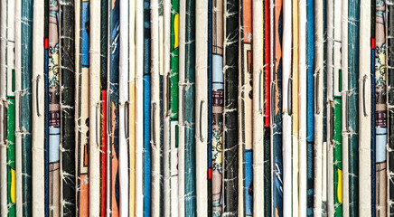 Vintage comic books collection stacked in a pile creates colorful background texture with old worn...