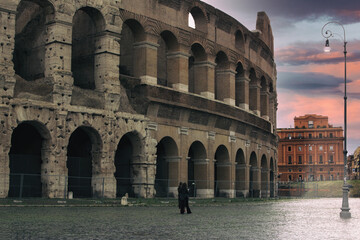 Fototapeta premium Rome, Italy at the Colosseum Amphitheater with the sunrise through the entranceway.
