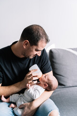 Dad feeds baby a bottle