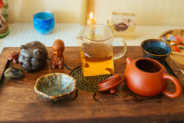  Chinese tea ceremony on bamboo table. Ceramic tea cups, clay teapot and tea pets close-up. 