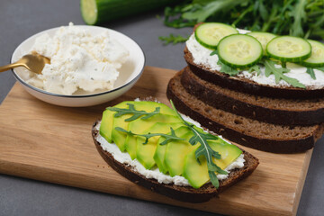 Healthy sandwich with white cottage cheese, avocado, cucumber and arugula