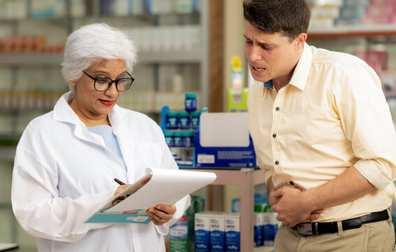 A young caucasian man consults a pharmacist about his illness.