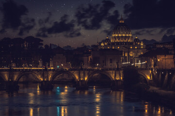 Ponte Sant`Angelo (Bridge of Holy Angel) and Basilica San Pietro (Saint Peter's cathedral) at night in Rome, Italy.