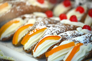 Close up view of typical sicilian cannoli stuffed with ricotta and candied fruits