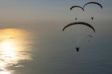 Paragliders flying above the ocean at sunset, Turkey
