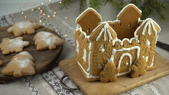 Gingerbread house Christmas homemade baking. Gingerbread Man. astle with white icing. Cookies in the shape of a Christmas tree and snowflakes on the table. Food for dessert. Winter gingerbread.