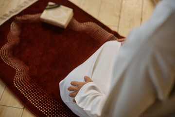 Close up of Muslim praying on traditional prayer mat.