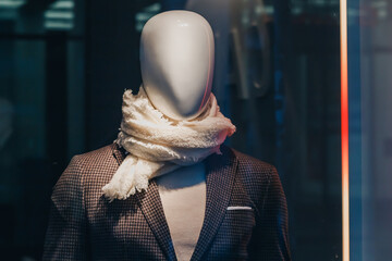 26 July 2022, Munster, Germany: clothing store with a showcase with male mannequin. Shopping and fashion industry