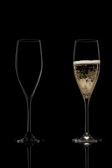 empty and full champagne glasses on black background