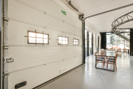 Wooden table placed in stylish light spacious with mechanical door