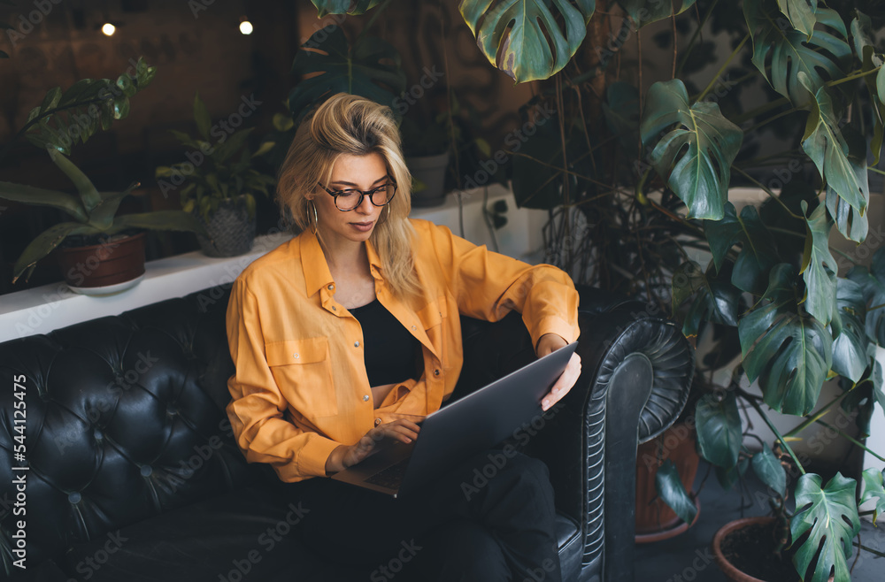Poster attractive freelancer in optical spectacles for vision correction watching browsed video on modern l