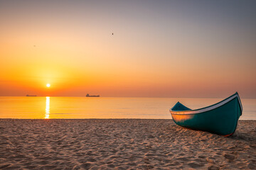 Peaceful sea sunrise over the beach and wooden fishing boat. Beautiful calmness morning for relaxation outdoor in the nature.