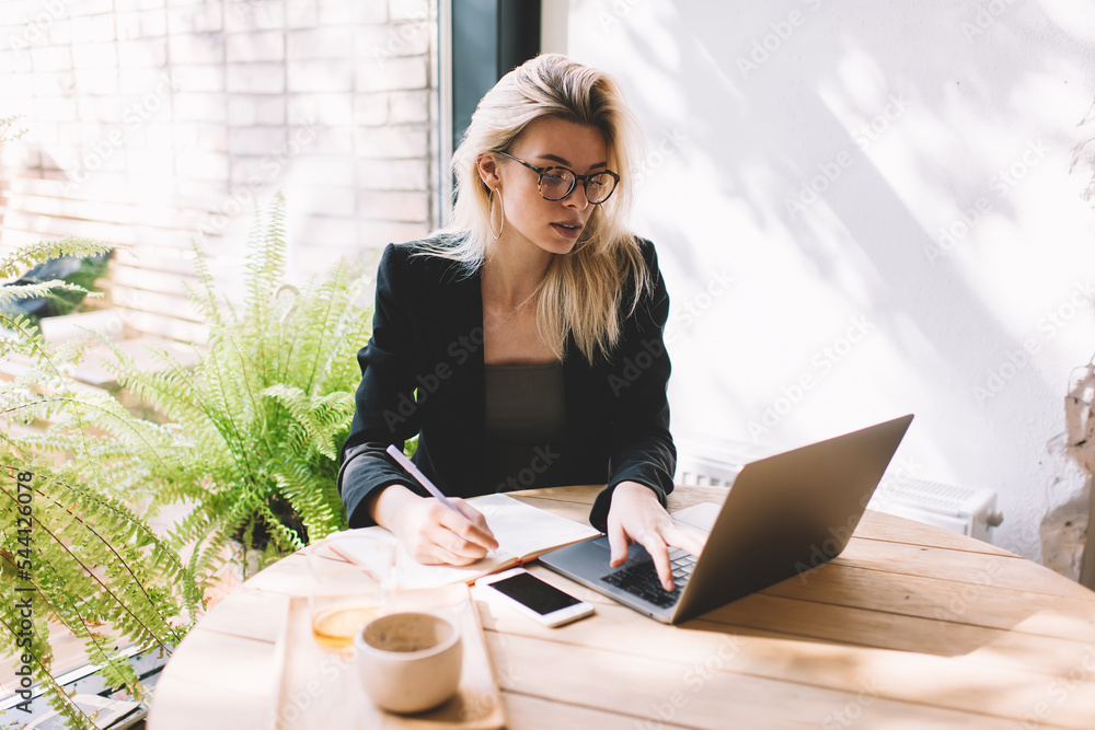 Poster caucasian female journalist with notepad using laptop application for planning content publications 
