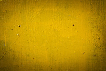 Rusty metal surface with yellow and brown paint flaking and cracking texture