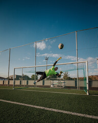 Vertical shoot of a goalkeeper trying stop a shoot.