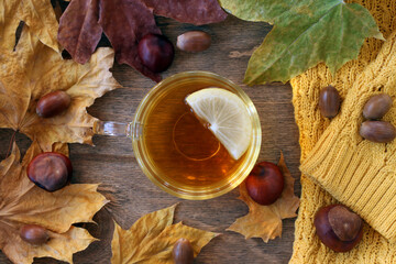 A cup of tea with a slice of lemon. Transparent cup of green tea on a wooden background. View from above.