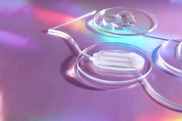 Smears of cream in petri dish on holographic background with iridescent highlights