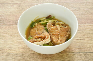 deep fried bass fish slice dressing soy sauce and spring onion on bowl