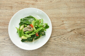 fried Chinese kale with chop salty fish in oyster sauce on plate 